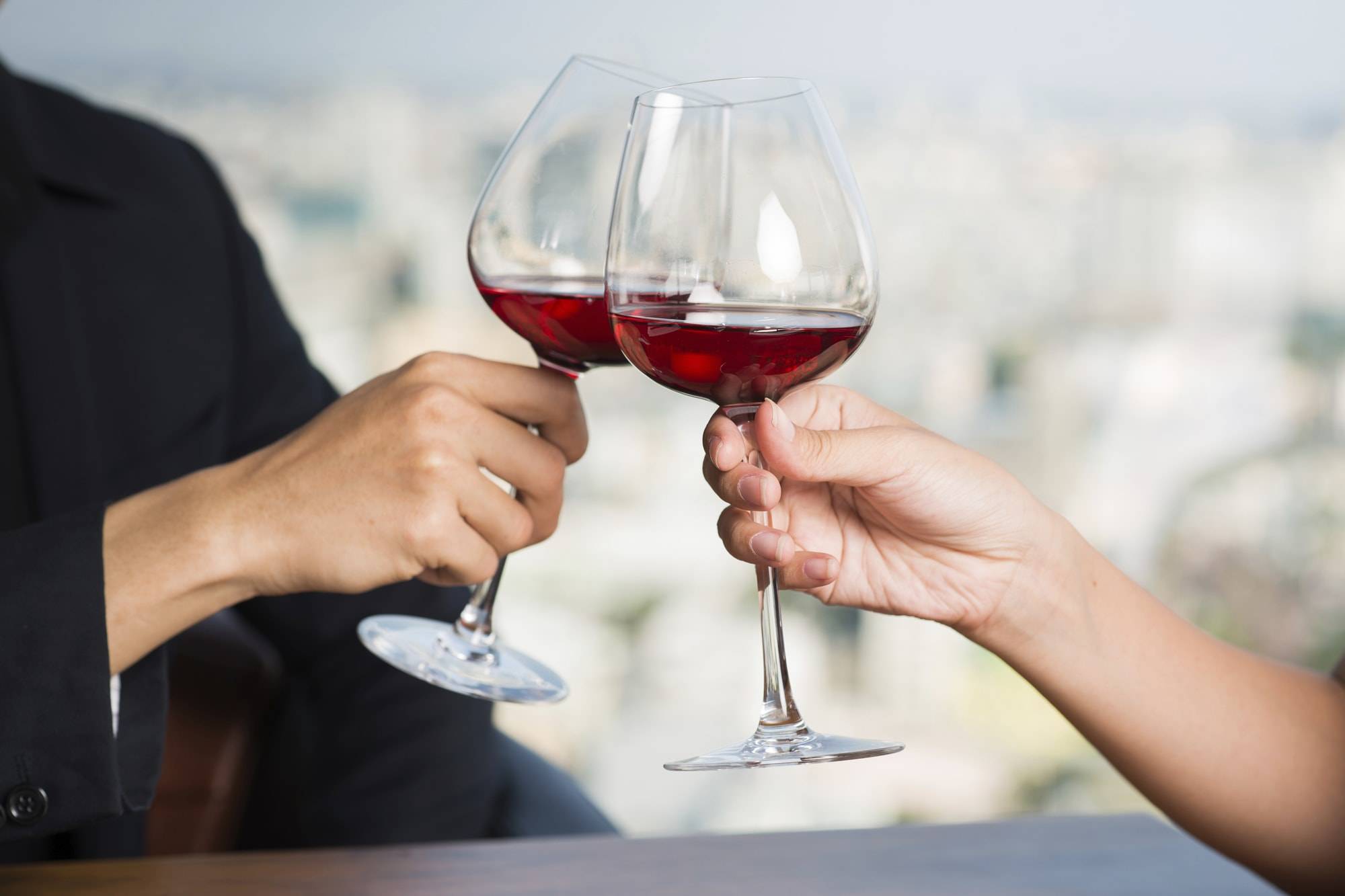 Мужчина и женщина чокаются бокалами вина